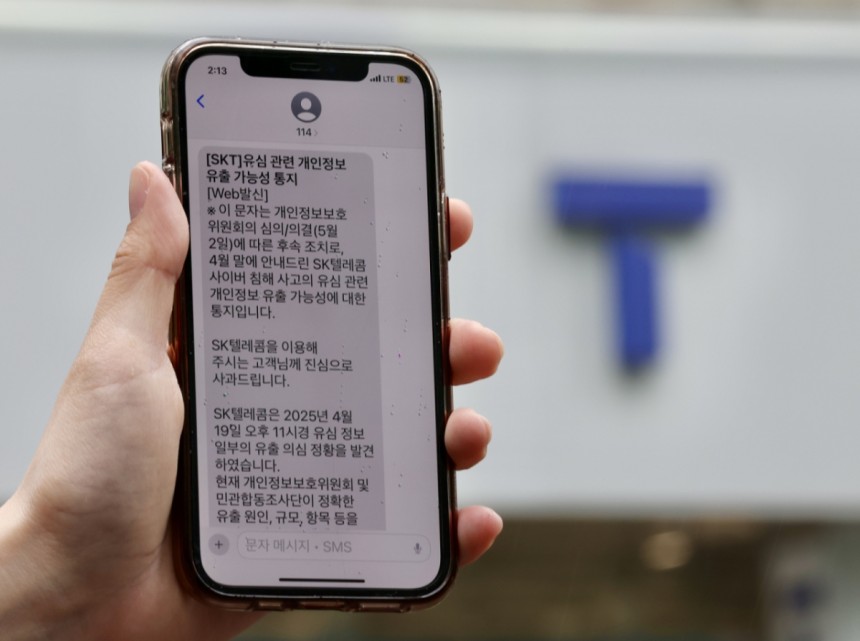 9일 서울 시내 한 SK텔레콤 대리점 앞에서 한 이용객이 문자메시지로 전송받은 개인정보 유출통지문을 보이고 있다./사진=뉴시스