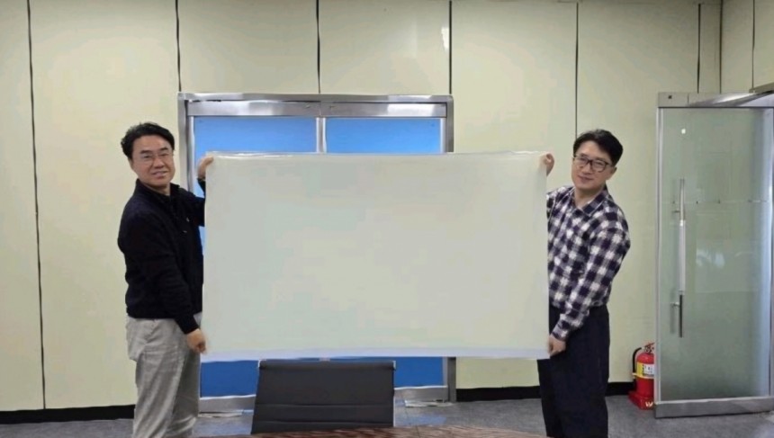 65인치 QD플레이트 시제품을 들고 있는 김동욱 큐텍 대표(왼쪽)와 김창건 큐텍 CTO/사진제공=큐텍