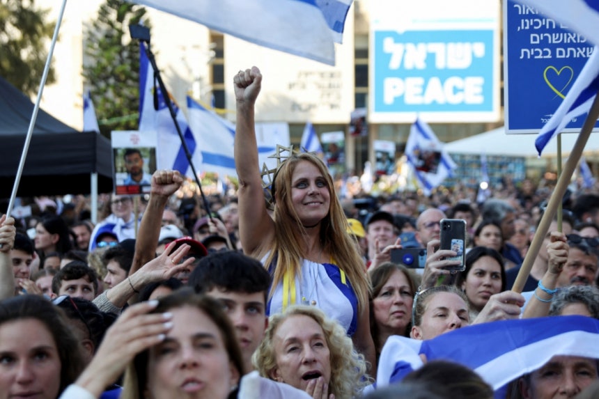 13일(현지시간) 하마스에 억류됐던 이스라엘 인질들이 석방됐다는 소식을 들은 이스라엘 시민이 텔아비브 '인질 광장' 집회에서 손을 들어보이고 있다./로이터=뉴스1