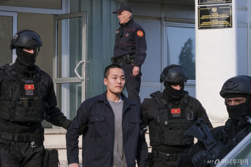 가상화폐 '테라·루나' 사태의 핵심 인물 권도형 테라폼랩스 대표가 작년 3월 23일(현지시각) 몬테네그로 포드고리차의 경찰청에서 조사를 받은 후 경찰관들에게 이끌려 나오고 있는 모습.[포드고리차=AP/뉴시스] /사진