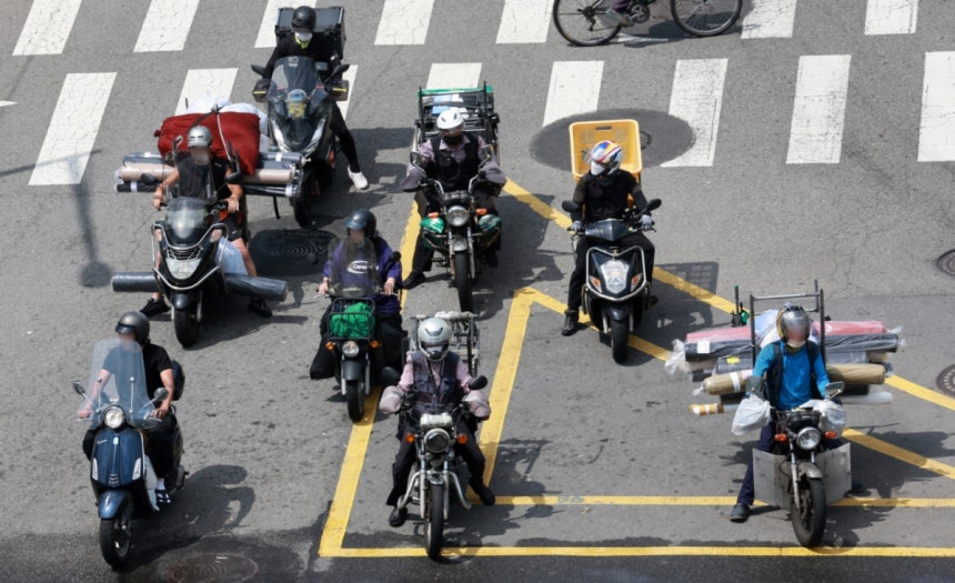 찜통 더위가 이어지고 있는 지난 7월23일 오후 서울 종로구의 한 도로에서 배달업 종사자들이 달궈진 아스팔트 위에서 신호를 기다리고 있다./사진=뉴시스