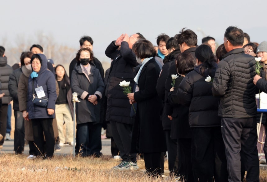 179명이 사망한 12·29 제주항공 무안공항 참사 1주기인 29일 전남 무안공항에서 유가족들이 활주로 내 피해를 키운 원인으로 지목된 방위각 시설물(로컬라이저)를 가까이서 바라보고 있다.한 유가족이 희생자 이름을