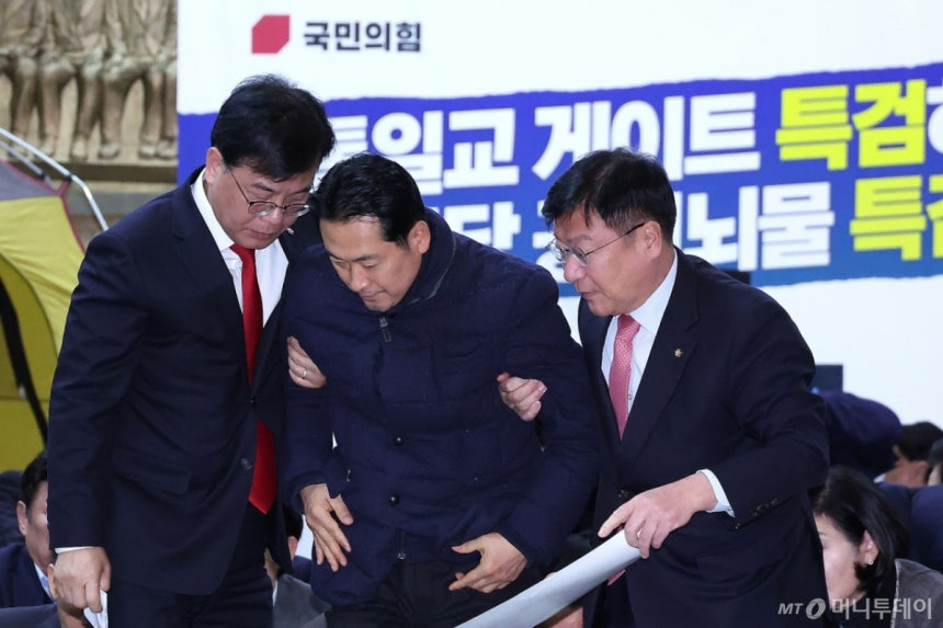 (서울=뉴스1) 신웅수 기자 = 장동혁 국민의힘 대표가 19일 서울 여의도 국회 로텐더홀에서 열린 통일교 게이트·더불어민주당 공천뇌물 특검 촉구 규탄대회를 마친 후 송언석 원내대표 등의 부축을 받고 있다.2026.