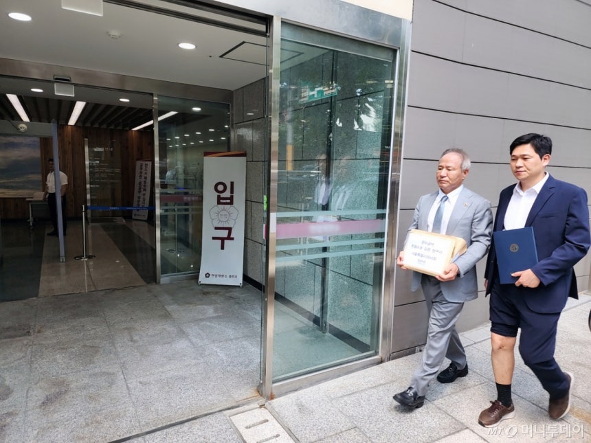 황규석(왼쪽) 서울시의사회 회장과 환자 남주성씨(오른쪽)가 '관리급여 헌법소원 심판 청구서'를 제출하기 위해 헌법재판소 민원실에 들어가고 있다./사진=정심교 기자