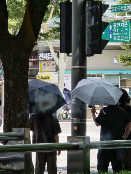 지난 6일 점심시간 서울 종로구 광화문 인근 점심을 먹기 위해 건물 밖을 나온 남성 직장인들이 양산을 쓰고 있다. /사진=박다영 기자