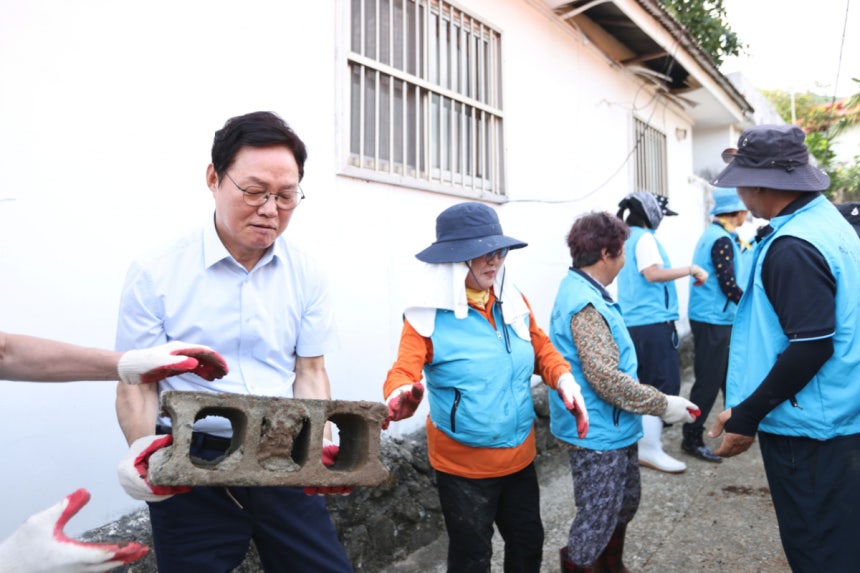 박완수 경남도지사(왼쪽)가 거제시 복구현장을 찾아 상황을 살펴보던 중 복구에 참여해 벽돌을 나르고 있다./사진제공=경남도
