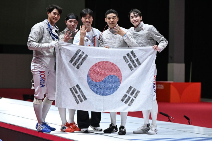 2026 아이치·나고야 아시안게임 펜싱 남자 사브르 단체전에서 대회 4연패를 달성한 한국 대표팀이 SK텔레콤 독자 AI 'A.X K2'로 국민 응원 메시지를 엮어 만든 '국민응원 태극기'를 들고 4연패를 뜻하는 손가