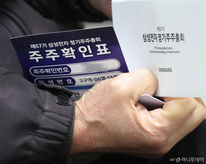 (수원=뉴스1) 김영운 기자 = 18일 오전 경기 수원시 영통구 수원컨벤션센터에서 열린 제57기 삼성전자 정기 주주총회에서 주주가 주주확인표를 들고 있다. (공동취재) 2026.3.18/뉴스1  Copyright (