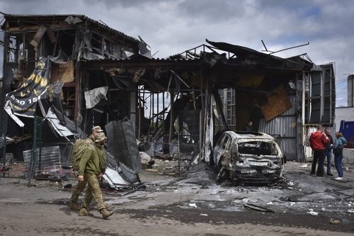  불타버린 드니프로의 한 주택 앞을 지나는 우크라이나군 병사들. [AP = 연합뉴스]