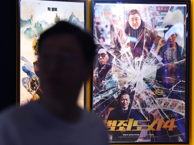 지난 5일 오전 서울 시내의 한 영화관에 걸린 범죄도시4 포스터 앞으로 관람객이 지나고 있다. [사진 출처 = 연합뉴스]