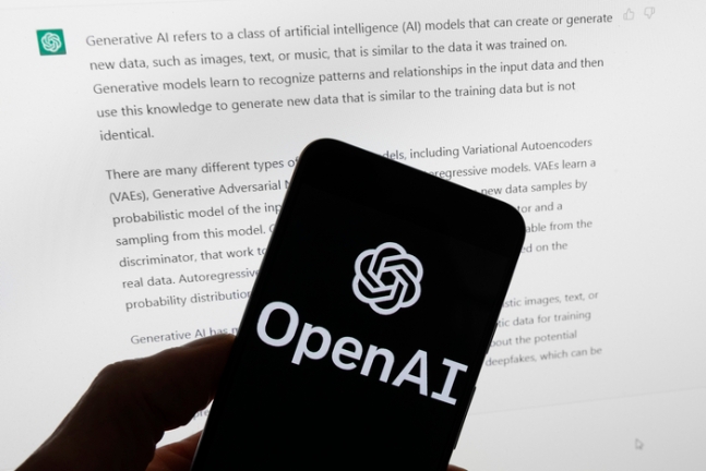  챗GPT의 결과를 표시하는 컴퓨터 화면 앞에 있는 OpenAI 로고가 있는 휴대폰 모습. AP연합뉴스
