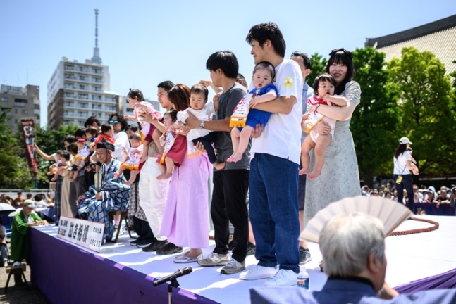  去る 4月東京で開かれた一行事で親たちが子供を抱いている. [連合ニュース]