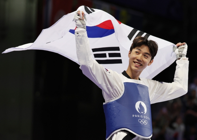 박태준이 8일 프랑스 파리 그랑팔레 태권도경기장에서 열린 2024 파리올림픽 태권도 남자 58kg급 결승전에서 승리해 금메달을 딴 뒤, 태극기 세리머니를 하고 있다. 연합뉴스