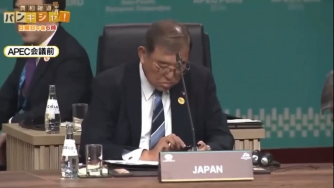  15일 APEC 회의에 참석한 이시바 총리가 스마트폰을 조작하고 있는 모습. [유튜브 캡처]