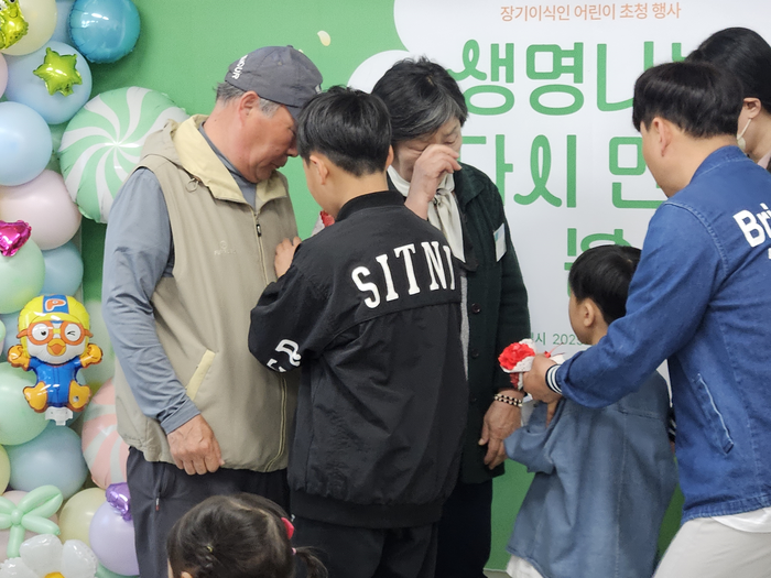  지난 1일 오전 서울 사랑의장기기증운동본부에서 강윤호 군(8) 가족이 도너패밀리에게 직접 만든 카네이션을 달아주고 있다.[사진 지혜진 기자]