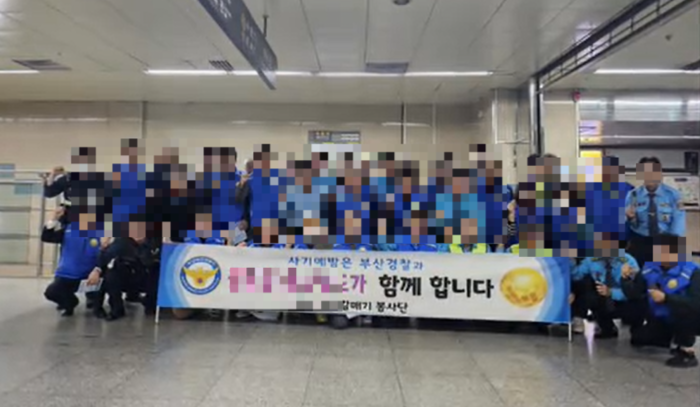  대규모 투자 사기 혐의로 수사 받고 있는 A사가 경찰들과 사기예방 캠페인 현수막을 들고 사진을 촬영 중이다.[독자 제공]