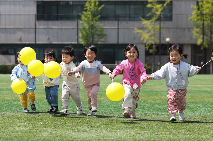  경기도 수원시 장안구 수원실내체육관에서 열린‘수원시 어린이 한마당’에서 어린이들이 환하게 웃으며 달리고 있다.[사진 출처 = 연합뉴스]