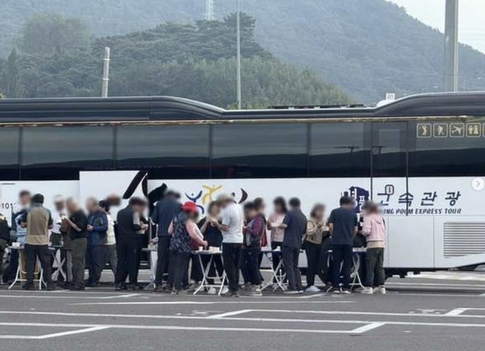 국내 한 고속도로 휴게소 주차장에서 대형버스 주차 공간을 점령한 채 테이블을 펴놓고 술자리를 벌인 관광객들의 모습이 포착됐다. [사진 = 온라인 커뮤니티 캡처]