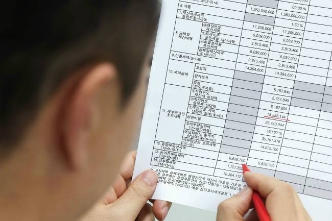 한 시민이 세금 납부 고지서를 보고 있다. [사진 = 연합뉴스]