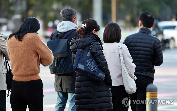  서울 아침 기온이 4도까지 떨어지면서 초겨울 날씨를 보이는 지난달 27일 서울 종로구 광화문 세종대로 사거리에서 출근길 시민들이 발걸음을 옮기고 있다.[연합뉴스]