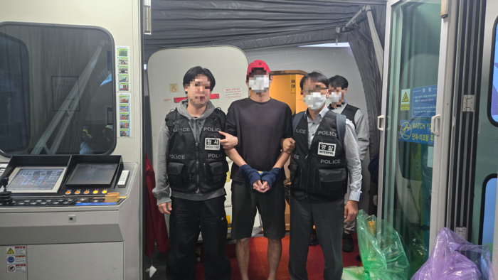 27일 오전 로맨스스캠 범죄 조직원인 30대 남성 A씨(가운데)가 베트남에서 한국으로 강제 송환되고 있다. [경찰청]