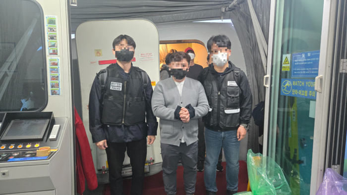 저작물 불법 유포 조직의 총책인 40대 남성 B씨(가운데)가 베트남에서 한국으로 강제 송환되는 모습. [경찰청]