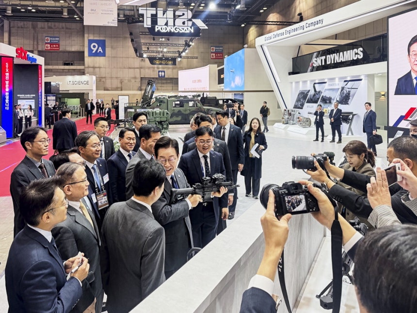 지난 10월 고양시 킨텍스에서 열린 '서울국제항공우주 및 방위산업 전시회(ADEX)' 개막식에 참석한 이재명 대통령이 SNT모티브 전시관을 찾아 관계자로부터 국산 소구경 화기에 대한 설명을 듣고 있다.SNT모티브