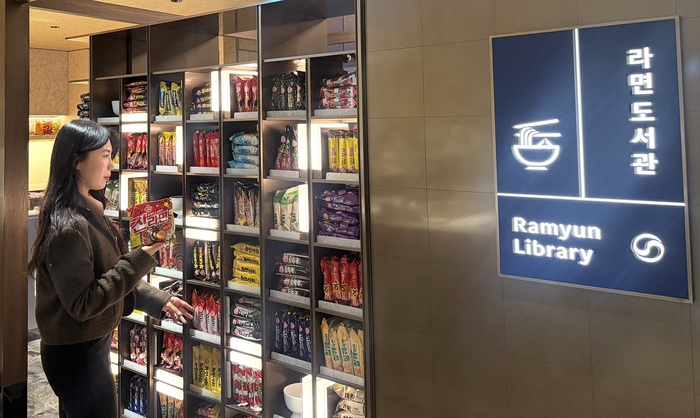 한 방문객이 다양한 라면이 진열된 ‘ 라면도서관 (Ramyun Library)’ 을 구경하고 있다 . 라면 도서관은 인천국제공항 제 2 여객터미널 (T2) 내 대한항공 프레스티지 동편 좌측 라운지에 설치됐다. [오