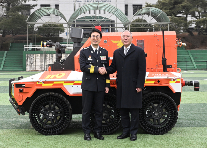  소방청 김승룡 소방청장 직무대행(왼쪽)과 현대차그룹 정의선 회장이 무인소방로봇과 함께 기념 촬영을 하고 있다. [현대차]