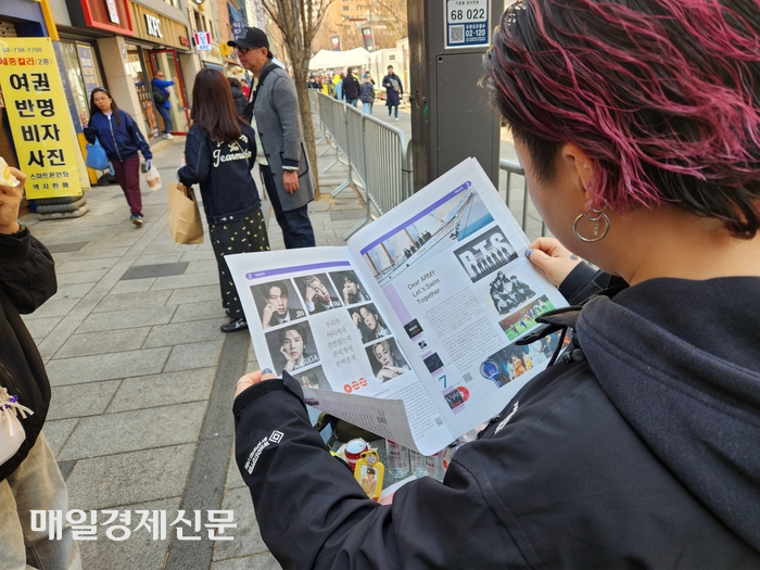  일본인 관광객이 매일경제가 배부한 BTS 특별판을 보고 있다.[조병연 기자]