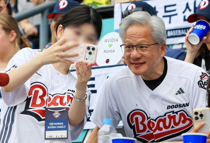  젠슨 황 엔비디아 최고경영자(CEO)가 7일 서울 잠실야구장에서 열린 2026 프로야구 KBO리그 키움 히어로즈와 두산 베어스의 경기를 관람하며 팬들과 기념사진을 촬영하고 있다.[연합뉴스]