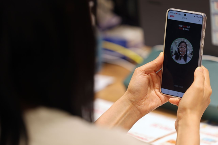 과학기술정보통신부 관계자가 지난달 30일 서울 중구의 한 통신사 대리점에서 휴대전화 개통 과정에서 안면인증을 시연하고 있다. [연합뉴스]