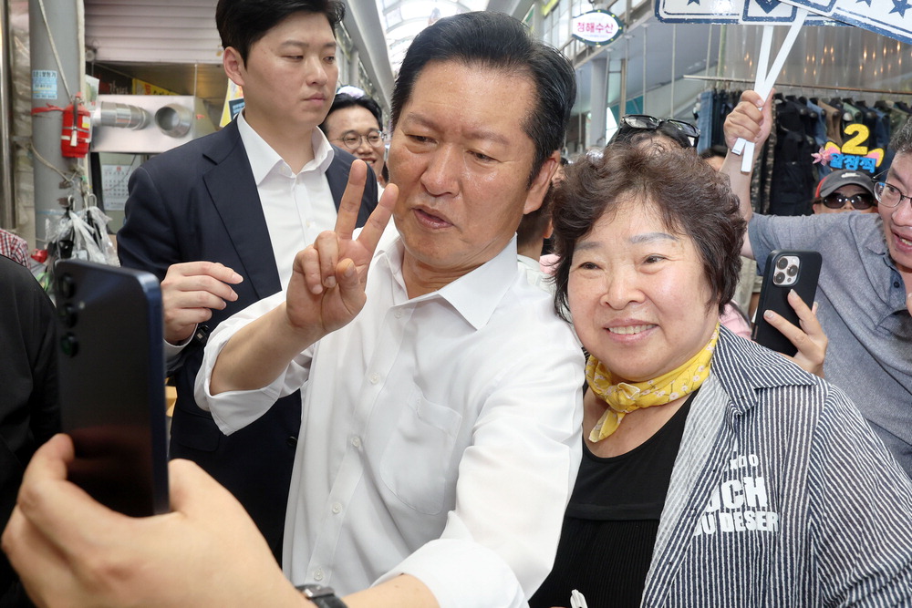 4일 전남광주 말바우시장에서 상인과 사진을 찍는 정청래 후보(왼쪽). 연합뉴스