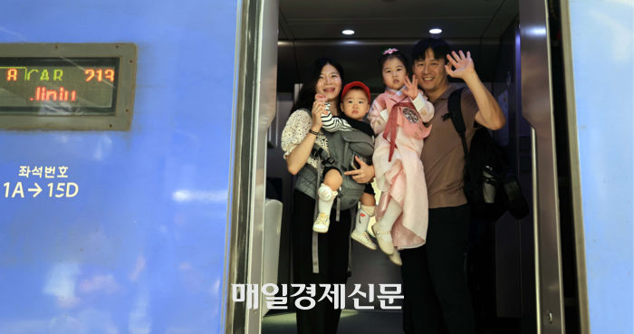  서울역 귀성길 열차에 탑승해 인사하는 가족의 모습. [김재훈 기자]