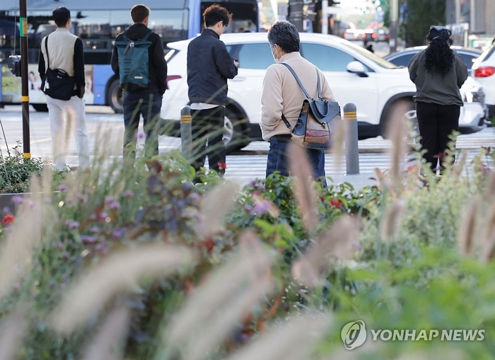  6일 서울 종로구 광화문광장에서 시민들이 횡단보도 앞에 멈춰서 있다.[연합뉴스]