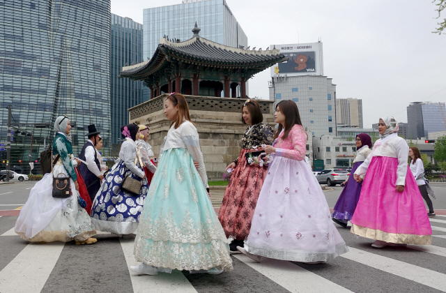 색색의 한복을 차려입은 외국인 관광객들이 서울 종로구 경복궁 동십자각 앞 건널목을 건너고 있다. /연합뉴스