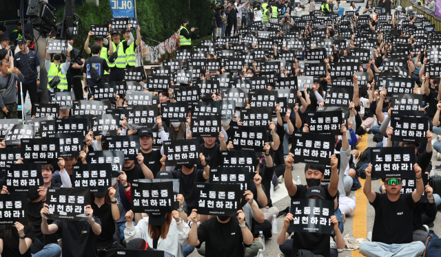 삼성전자 노조가 24일 서울 서초사옥 앞에서 검은색 피켓을 들고 구호를 외치고 있다. 뉴스1