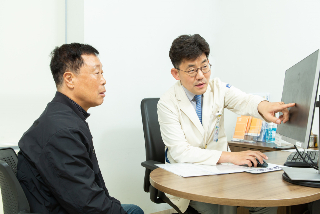 여창동(오른쪽) 은평성모병원 호흡기내과 교수가 이현술씨에게 폐암 치료 경과를 설명하고 있다. 사진 제공=은평성모병원