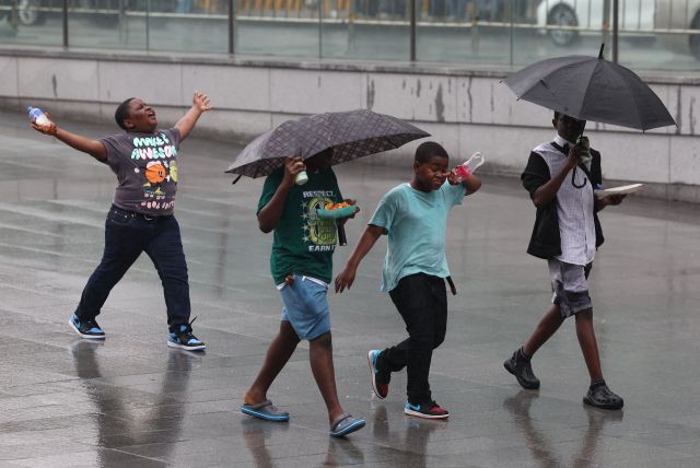 5월 26일 오후 비가 내리는 서울 광화문광장에서 외국인 학생들이 비를 맞으며 걸어가고 있다. 연합뉴스