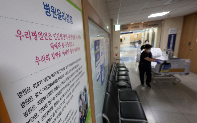 9일 대구 중구 경북대학교병원에 붙어있는 병원 윤리강령 앞으로 의료관계자가 병상과 함께 이동하고 있다. 연합뉴스