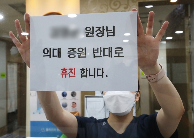 17일 경기도의 한 의원에 의료진이 18일 의대정원 증원에 반대하며 휴진한다는 안내문을 붙이고 있다. 뉴스1
