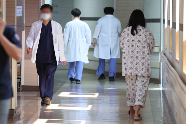 전국 의사들이 집단 휴진한 18일 광주 동구 전남대병원에서 환자와 의료인이 복도를 지나치고 있다. 연합뉴스