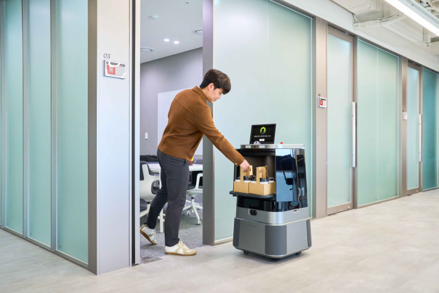 현대차·기아의 배달 로봇 ‘달이 딜리버리’가 모바일 앱으로 주문한 고객 사무실로 배달한 커피를 건네고 있다. 사진제공=현대차그룹