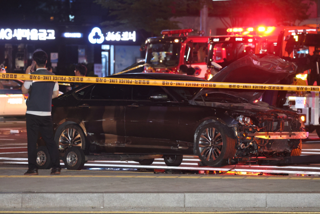 2일 새벽 서울 시청역 인근 교차로에서 경찰이 전날 대형 교통사고로 완전히 파괴된 차량 한 대 주변을 통제하고 있다.연합뉴스