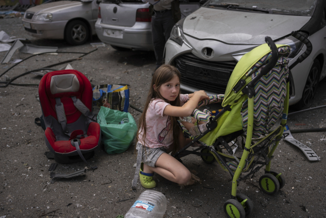 폴리나(10)가 8일 러시아 미사일에 공격당한 키이우 오크흐마트디트 어린이 병원 부지에서 여동생을 돌보고 있다. AP연합뉴스