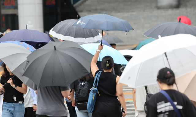 지난 8일 서울 용산역광장을 향한 시민들이 우산을 쓰고 횡단보도를 건너고 있다. 연합뉴스