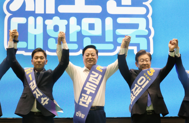 Kim Ji-soo, Kim Du-kwan, and Lee Jae-myung, representative candidates (from left) are holding hands for a photo time at a joint campaign held at Hana Gymnasium in Jeju City on the 20th before the general meeting to elect a new leadership of the Democratic Party. Yonhap News