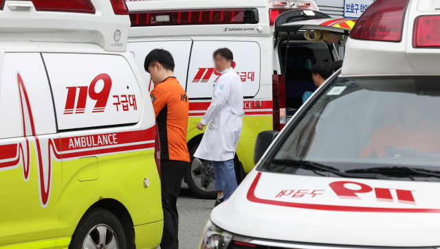 Medical professionals moving in front of the emergency room of a tertiary hospital in Daegu where an ambulance is waiting. Yonhap News