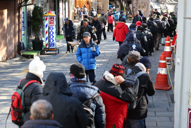 ２４日、ソウル鍾路区（チョンノグ）の塔骨公園原閣寺老人無料給食所の前が食事を待つ大人たちで混んでいる。連合ニュース