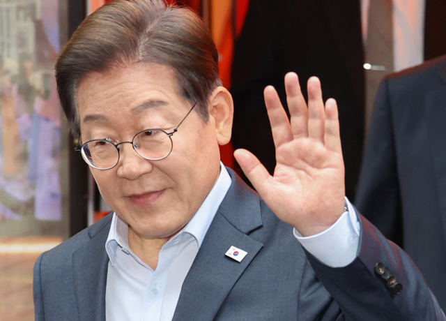 이재명 더불어민주당 대선 후보가 1일 서울 종로구의 한 포차 식당에서 ‘당신의 하루를 만드는, 보이지 않는 영웅들’이라는 주제로 열린 배달라이더·택배기사 등 비(非)전형 노동자들과의 간담회를 마친 뒤 나서며 손인사를